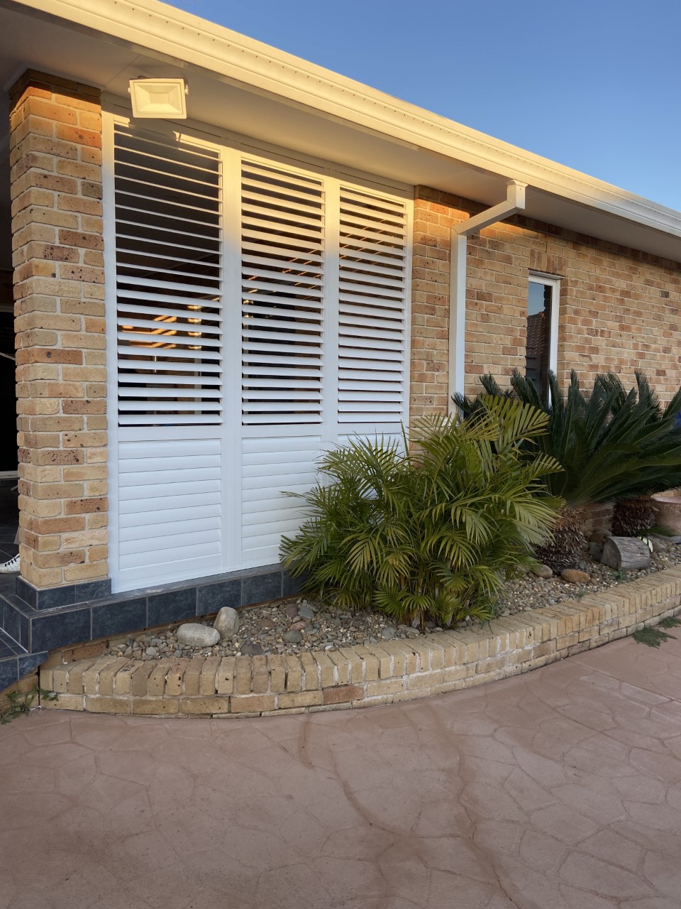 Aluminium shutters on a brick home exterior