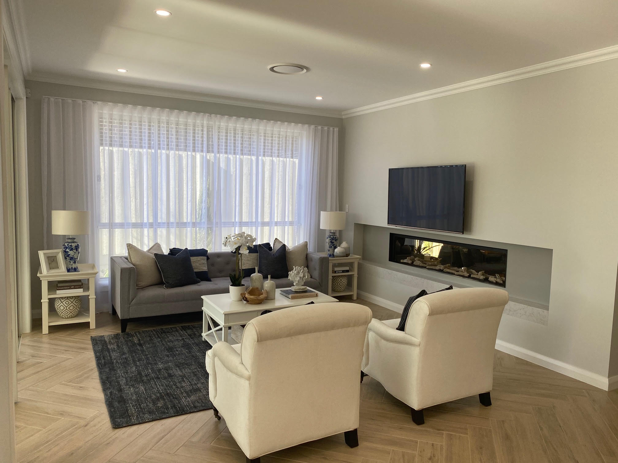 Sheer curtains in a modern living room with TV and sofa