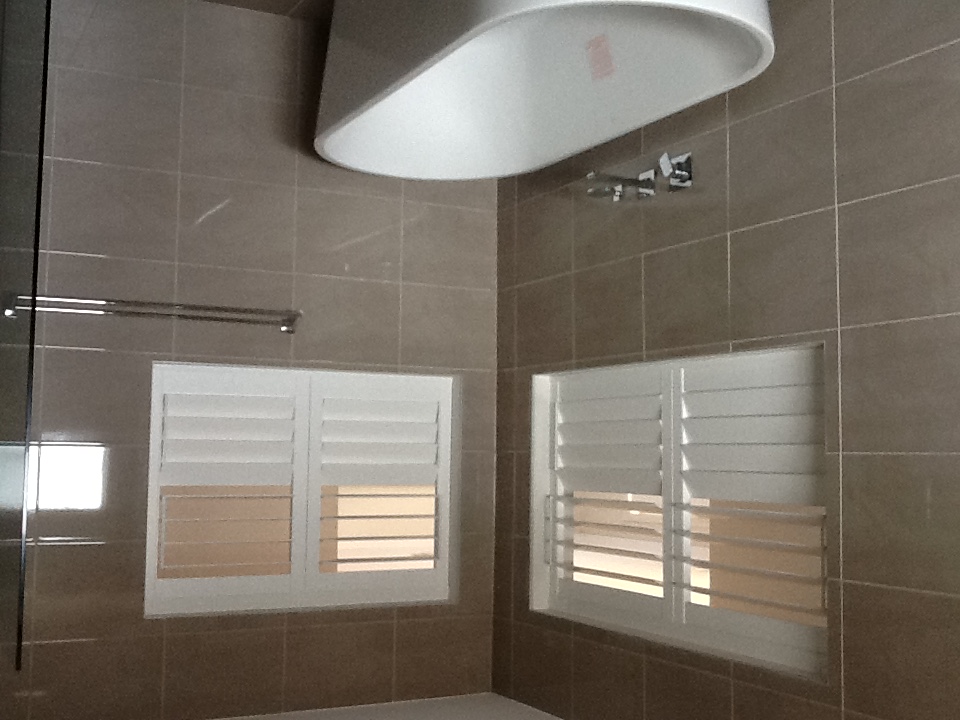White PVC shutters in a tiled bathroom