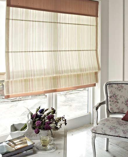 Striped Roman blind beside a floral upholstered chair